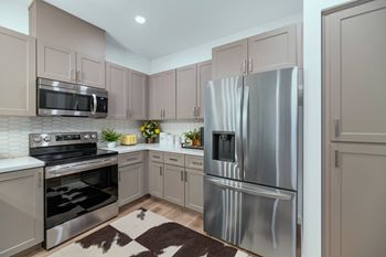 A kitchen with stainless steel appliances and white cabinets